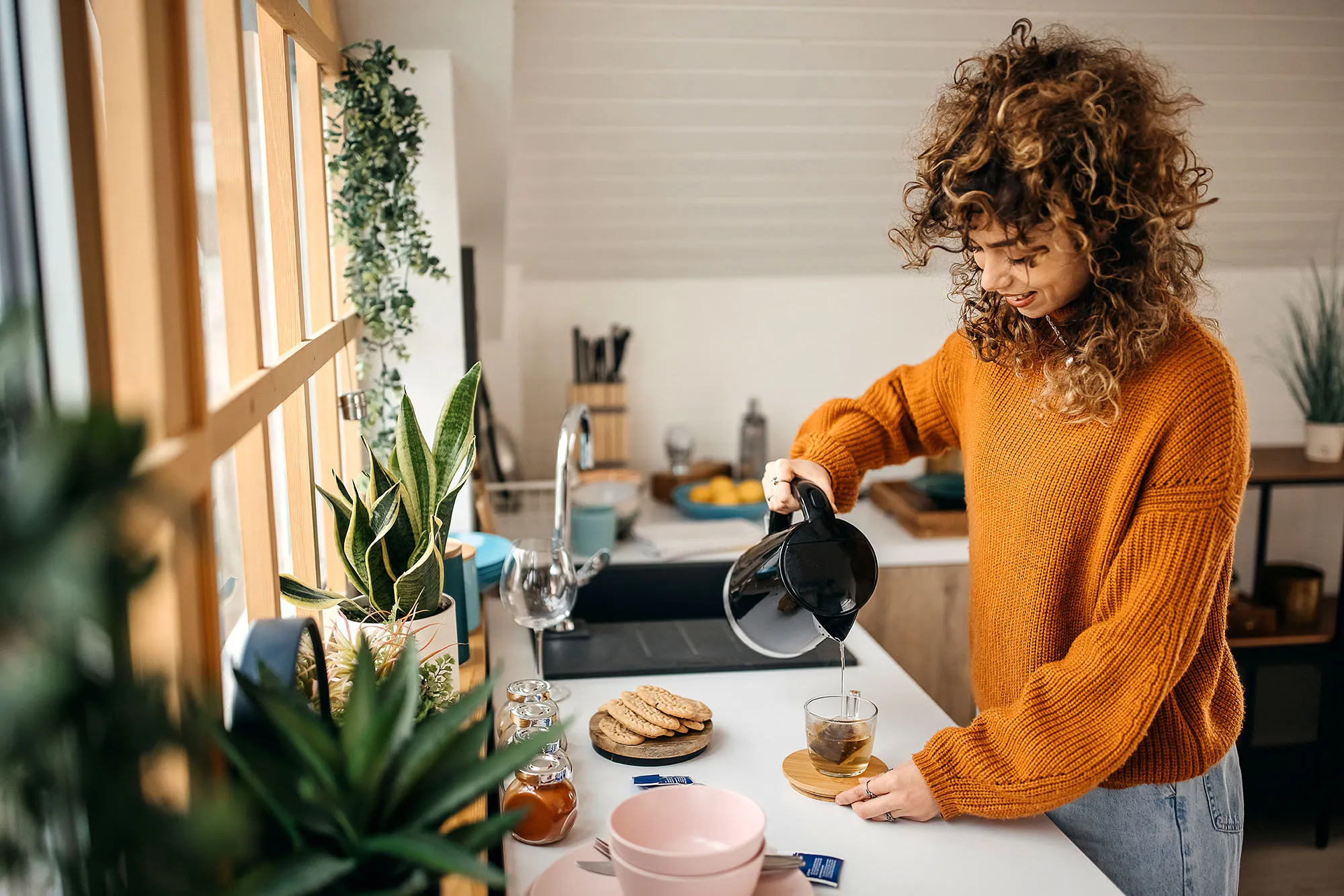 Cropped shot of an attractive young woman making herself some tea in her small kitchen at home