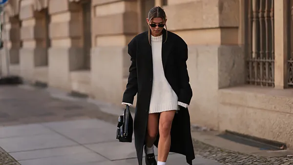 BERLIN, GERMANY - OCTOBER 15: Sophia Geiss is seen wearing oval rimless black sunglasses from Vehla Eyewear; two different-sized gold hoop earrings; a silver nose ring; an ankle-length, oversized black coat with shoulder-ads and notch lapels from 032c; an oversized knit pullover with high round neckline from Black Palms underneath; a rectangular black leather handbag featuring two small pockets of various sizes and a short leather strap from Liebeskind Berlin; and white socks paired with black leather loafers with silver horsebit buckle from LeGer on October 15, 2024 in Berlin, Germany. (Photo by Jeremy Moeller/Getty Images)