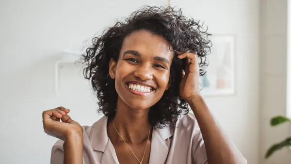 Fresh start of the morning. Young woman in bathroom applying moisturizing cream on her skin after having a bath.