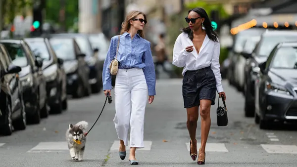 two women walking dog in city