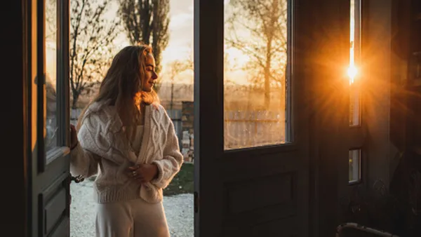 woman wearing beige matching set by door