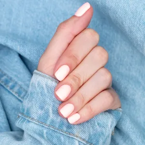 Bright neon red manicure on female hands on the background of jeans. Nail design. Beauty hands.