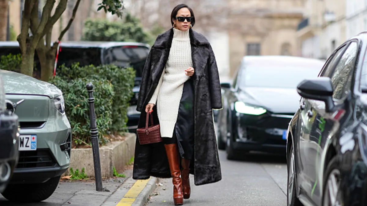 woman wearing sweater dress, coat and boots