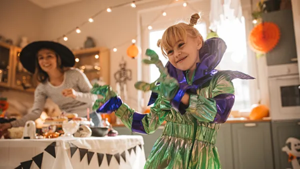 kid in halloween costume with mom