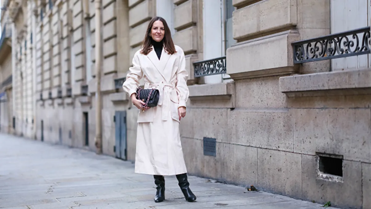 woman wearing cream jacket and black boots
