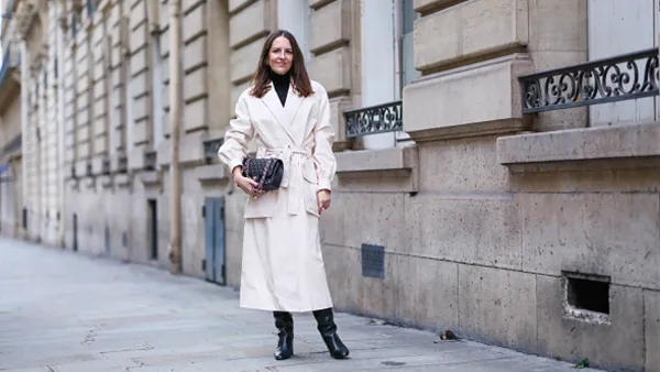 woman wearing cream jacket and black boots