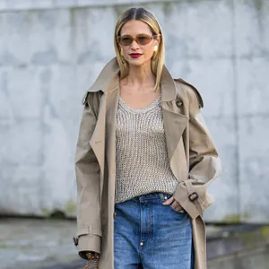 woman wearing sweater, trench coat and blue jeans