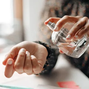 Woman spraying perfume on wrist