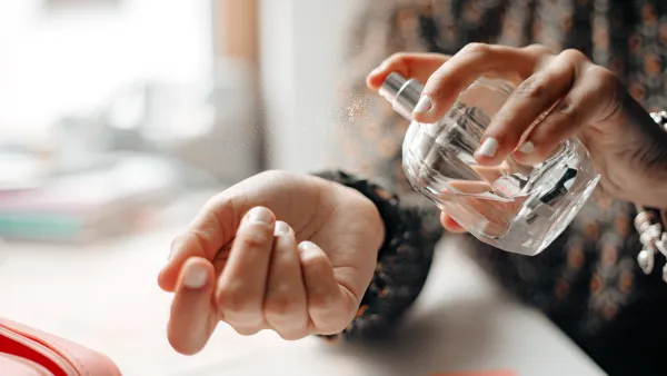 Woman spraying perfume on wrist