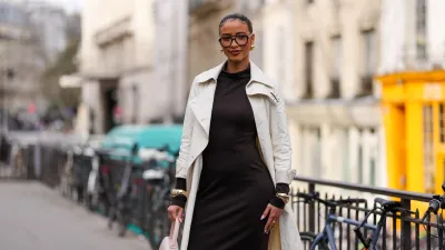 PARIS, FRANCE - MARCH 09: Flora Coquerel wears black sunglasses, gold earrings, dark brown high neck long sleeve midi dress, cream trench coat, gold bracelets, outside Akris, during the Paris Fashion week Women's Fall/Winter 2025-2026 on March 9, 2025 in Paris, France. (Photo by Edward Berthelot/Getty Images)