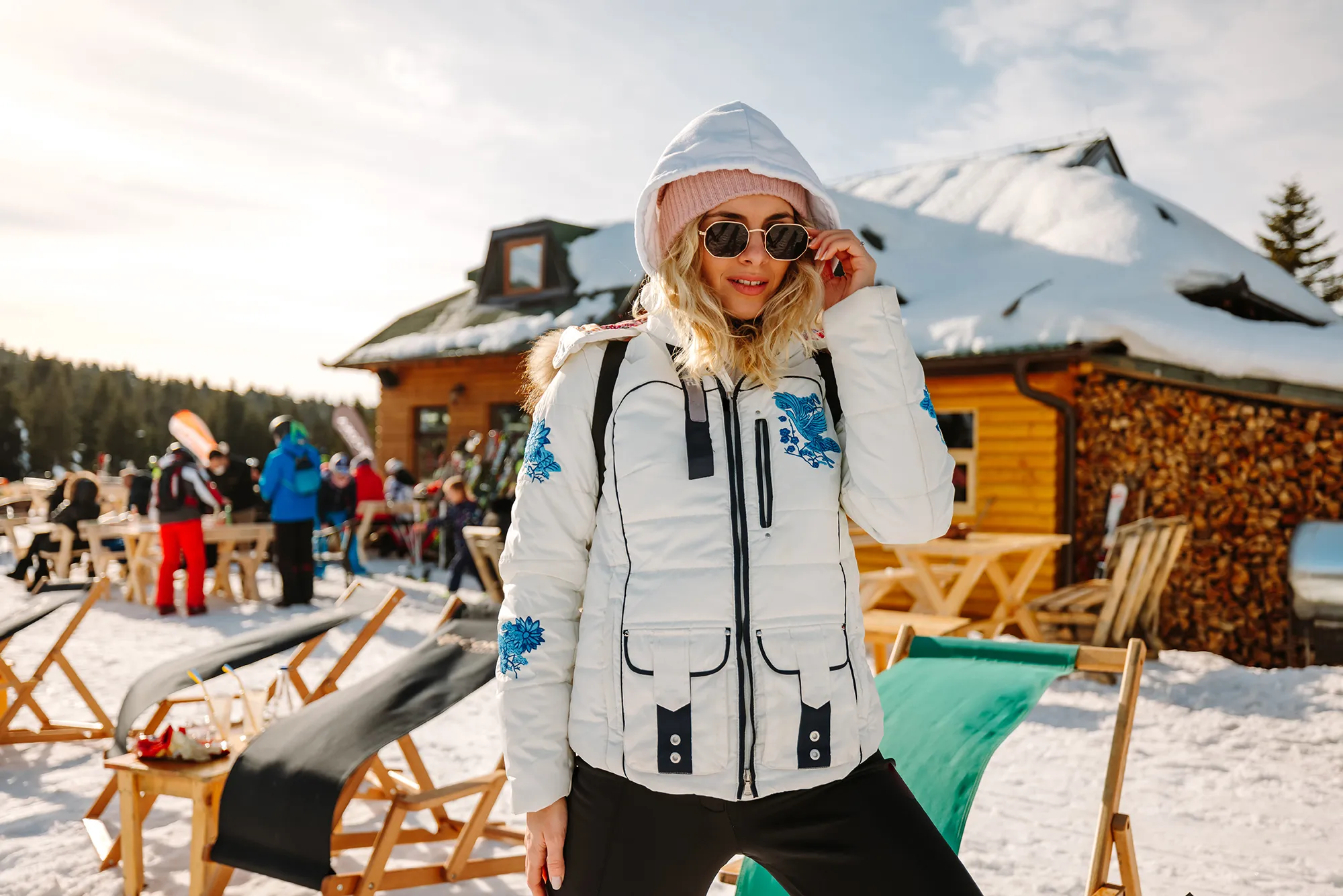 Beautiful young woman posing in ski resort on sunny winter day
