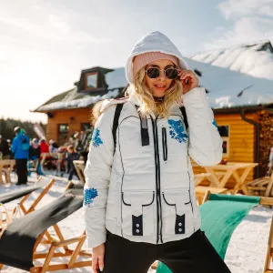 Beautiful young woman posing in ski resort on sunny winter day