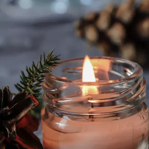 Lit,scented, mason jar candle with pine cones and bokeh/Christmas decoration