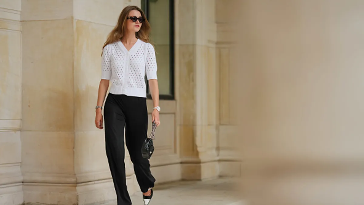 woman wearing white cardigan and black pants