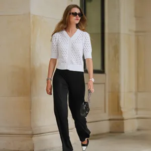 woman wearing white cardigan and black pants