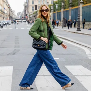 woman wearing jeans walking across the street
