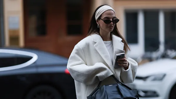 woman wearing white coat and head band and black sunglasses