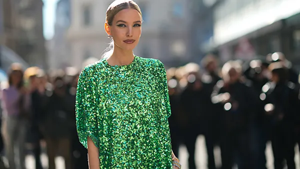 MILAN, ITALY - FEBRUARY 26: Leonie Hanne wears silver and rhinestones earrings from Balenciaga, a green shiny sequined oversized t-shirt dress, rhinestones bracelets, outside the Ermanno Scervino fashion show, during Milan Fashion Week Fall/Winter 2022/2023 on February 26, 2022 in Milan, Italy. (Photo by Edward Berthelot/Getty Images)