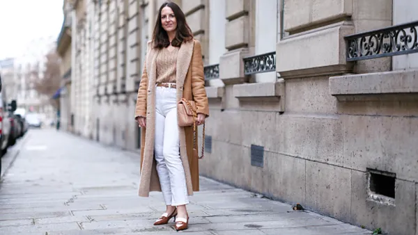 woman wearing beige sweater, white pants and tan jacket