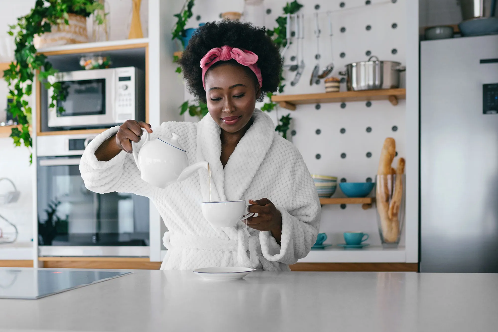 Young woman drinking tea at her kitchen in the morning.