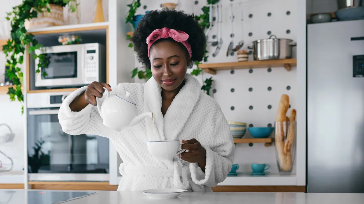 Young woman drinking tea at her kitchen in the morning.