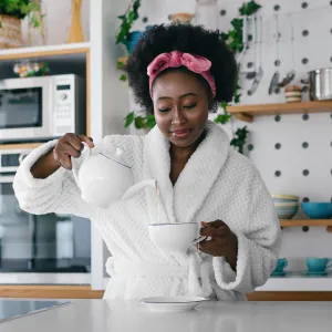 Young woman drinking tea at her kitchen in the morning.