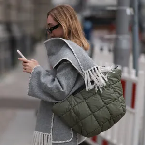 BERLIN, GERMANY - APRIL 22: Sonia Lyson seen wearing Linda Farrow x The Attico black sunglasses, gold earrings, Toteme light grey wool scarf jacket / short coat, Lala Berlin khaki green silk cargo pants, Vee Collective khaki green nylon shopper bag, on April 22, 2024 in Berlin, Germany. (Photo by Jeremy Moeller/Getty Images)