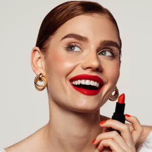 Beautiful emotional woman with bright make-up applying red lipstick