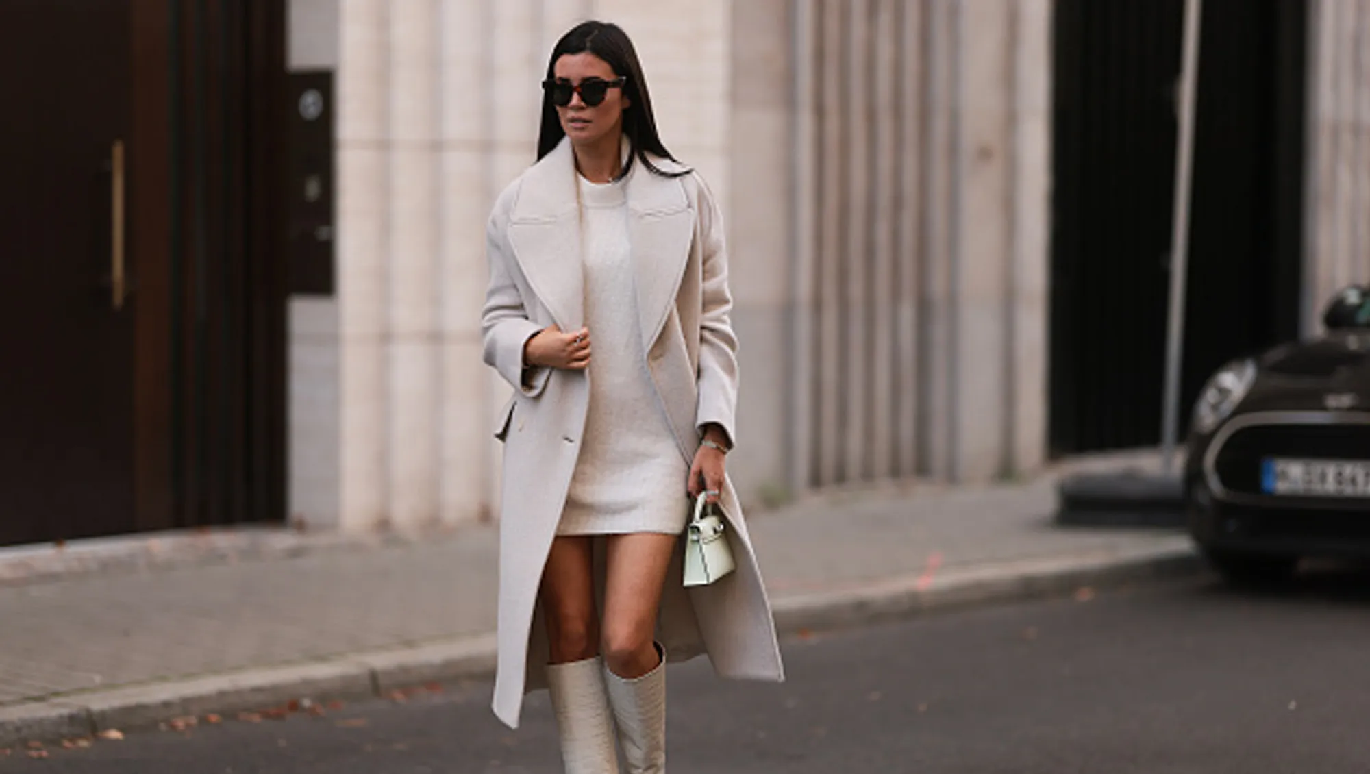 Leo Eberlin wearing Zara beige coat, H&M beige knit sweater dress, Hermes light green mini leather Kelly bag, Paris Texas beige leather boots, Celine brown shades and Leo Mathild jewelry on October 28, 2022 in Berlin, Germany.