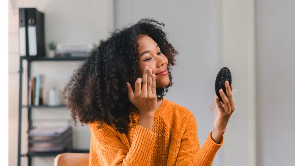 Woman Applying Makeup at Replica Luxury Handbag