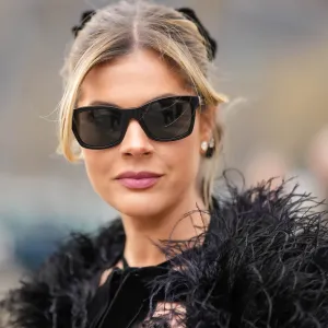 PARIS, FRANCE - MARCH 07: Lala Rudge wears black sunglasses, diamonds earrings, a black velvet with lace print pattern halter-neck long dress, a black feathers cloak, outside Chanel, during Paris Fashion Week - Womenswear Fall Winter 2023 2024, on March 07, 2023 in Paris, France. (Photo by Edward Berthelot/Getty Images)