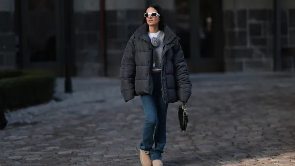 BERLIN, GERMANY - NOVEMBER 30: Anna Winter seen wearing Bottega Veneta white sunglasses, white cotton top, Balenciaga black puffer winter jacket, Rotate grey wool knit v-neck sweater / pullover with a flower detail, blue denim long jeans / pants, Dior black leather Saddle bag and UGG beige platform suede leather winter boots, on November 30, 2023 in Berlin, Germany. (Photo by Jeremy Moeller/Getty Images)