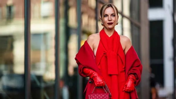 A guest wears a red full outfit, a halter top / long dress, a red long coat, red leather gloves, a Chanel bag, outside Carolina Herrera, during New York Fashion Week, on February 12, 2024 in New York City.