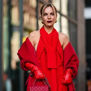A guest wears a red full outfit, a halter top / long dress, a red long coat, red leather gloves, a Chanel bag, outside Carolina Herrera, during New York Fashion Week, on February 12, 2024 in New York City.