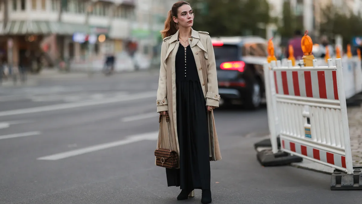 BERLIN, GERMANY - SEPTEMBER 22: Frankie Miles wearing black maxi dress, beige trenchcoat, black boots, and brown bag on September 22, 2021 in Berlin, Germany. (Photo by Jeremy Moeller/Getty Images)
