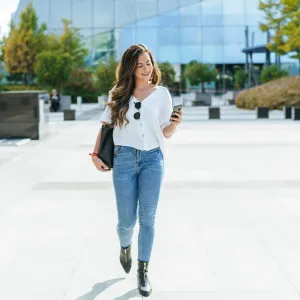 Business woman walked while using smartphone.