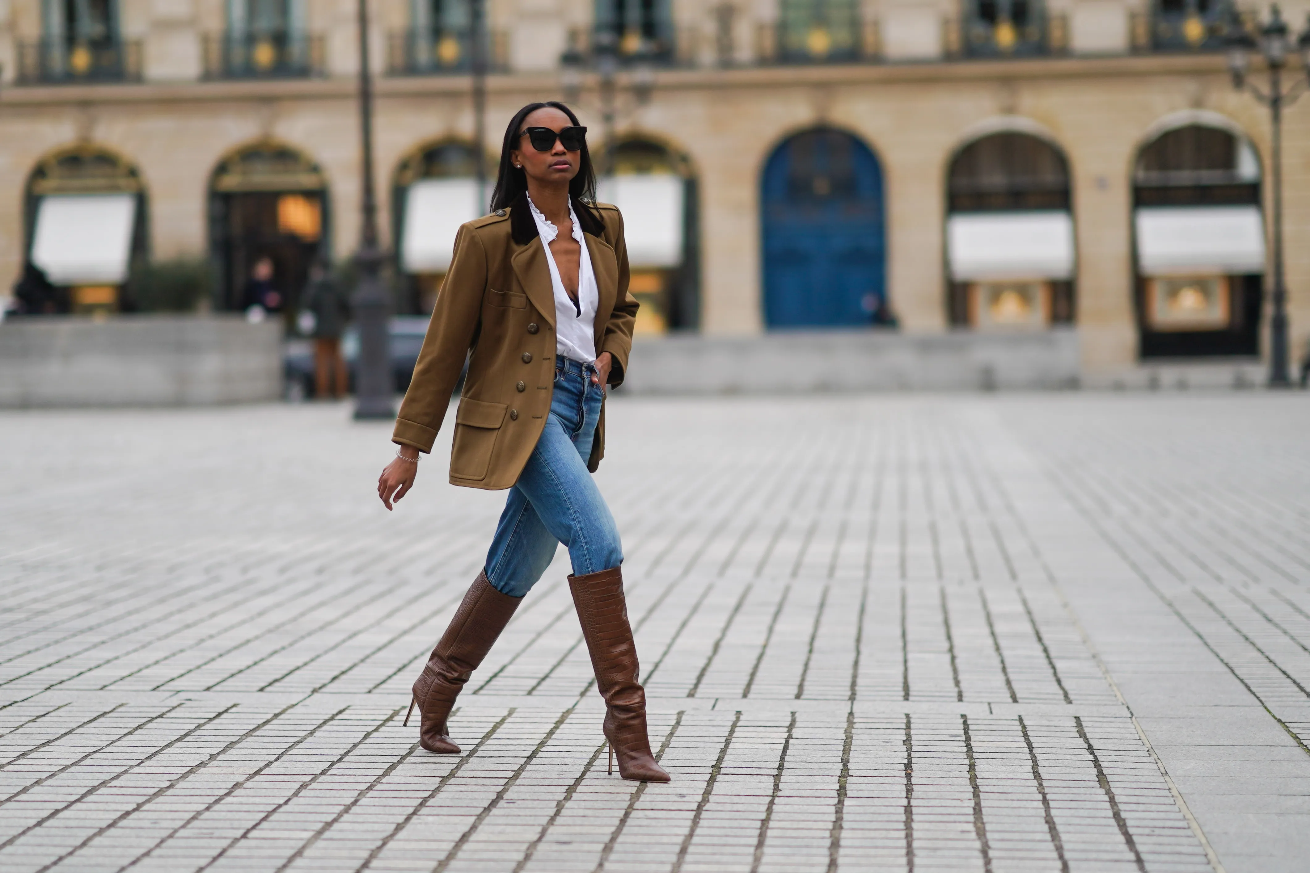 woman wearing blue jeans, brown jacket and boots