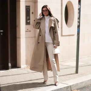 woman wearing beige coat, white sweater and cream pants
