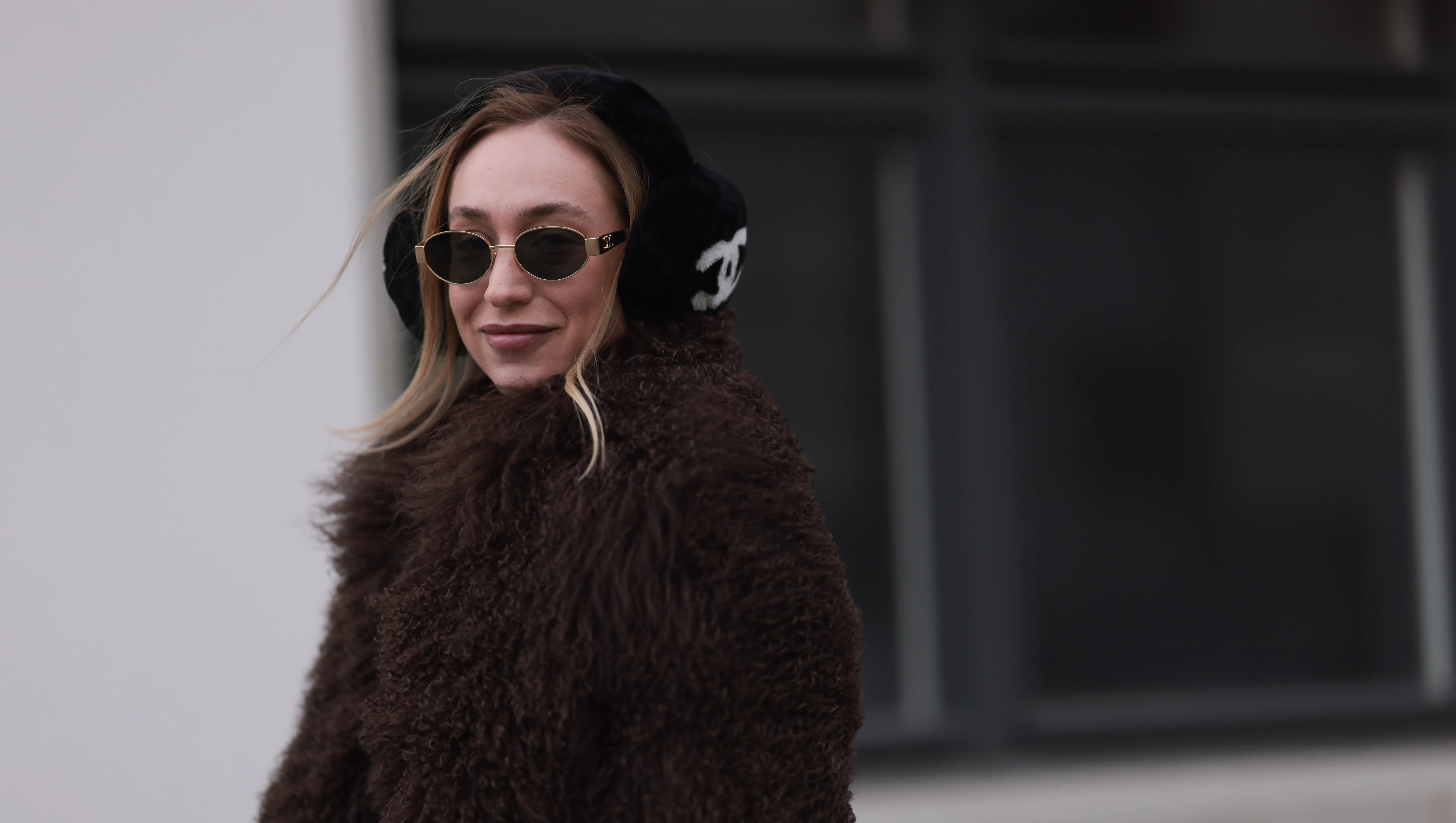 BERLIN, GERMANY - JANUARY 15: Sonia Lyson seen wearing Celine gold Triomphe metal sunglasses, Chanel black with white logo pattern fake fur ear muffs, Ducie London brown fake fur jacket / coat, on January 15, 2024 in Berlin, Germany. (Photo by Jeremy Moeller/Getty Images)