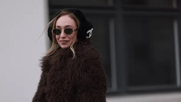BERLIN, GERMANY - JANUARY 15: Sonia Lyson seen wearing Celine gold Triomphe metal sunglasses, Chanel black with white logo pattern fake fur ear muffs, Ducie London brown fake fur jacket / coat, on January 15, 2024 in Berlin, Germany. (Photo by Jeremy Moeller/Getty Images)