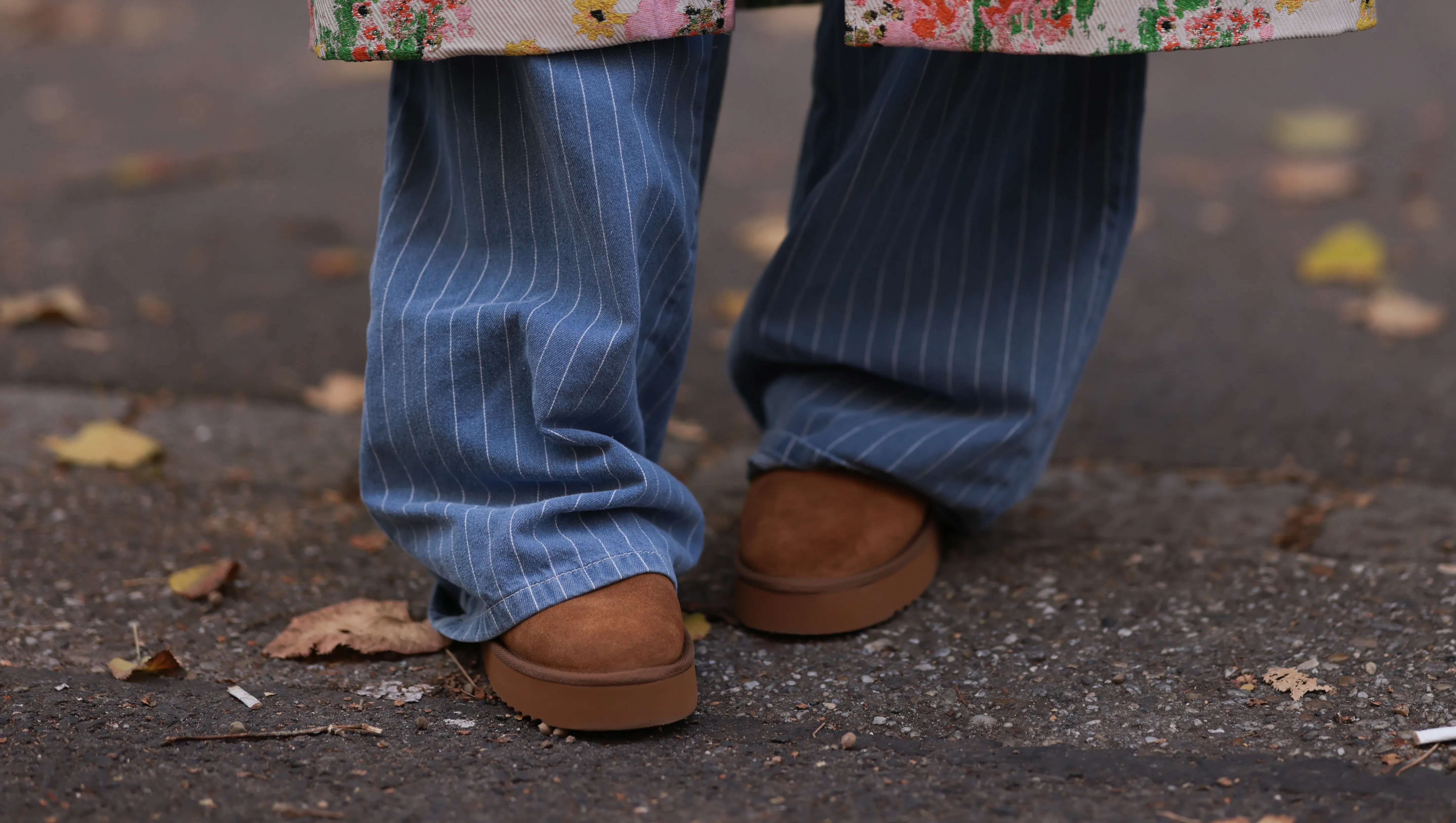 VIENNA, AUSTRIA - NOVEMBER 05: Karin Teigl is seen wearing a calf-length multicolored coat with floral embroideries from Stine Goya; wide pinstriped jeans from Baum & Pferdgarten; and brown suede platform slippers from Copenhagen Studios on November 05, 2024 in Vienna, Austria. (Photo by Jeremy Moeller/Getty Images)