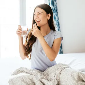 Healthy young woman taking supplements