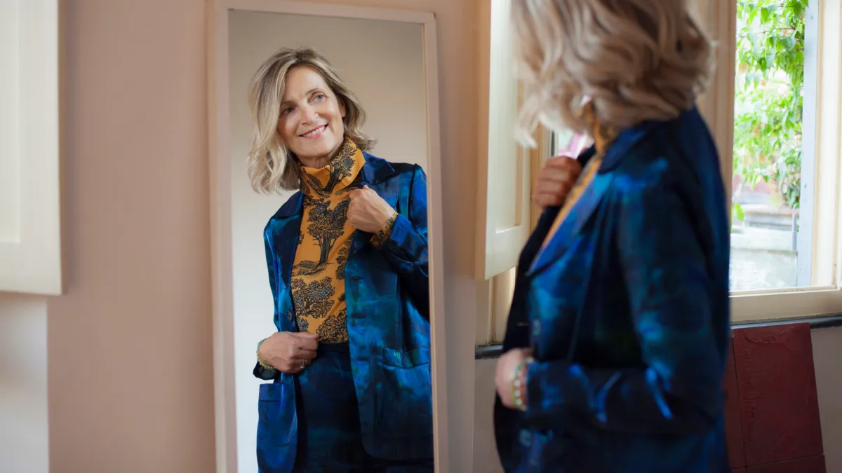 Beautiful mature woman checking herself in the mirror