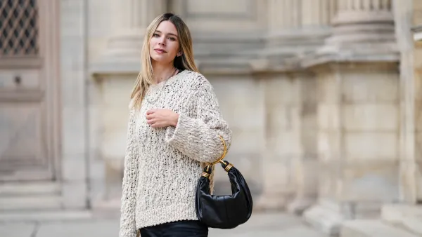 Natalia Verza wears a white oversized cozy Dorothee Schumacher sweater, a black leather Chloe bracelet bag, during a street style fashion photo session, on October 04, 2024 in Paris, France.