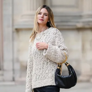 Natalia Verza wears a white oversized cozy Dorothee Schumacher sweater, a black leather Chloe bracelet bag, during a street style fashion photo session, on October 04, 2024 in Paris, France.