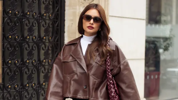 PARIS, FRANCE - SEPTEMBER 29: Max Collins wears black mini skirt, black tights, white turtle neck top, brown leather jacket and burgundy bag during Womenswear Spring/Summer 2025 as part of Paris Fashion Week on September 29, 2024 in Paris, France. (Photo by Raimonda Kulikauskiene/Getty Images)
