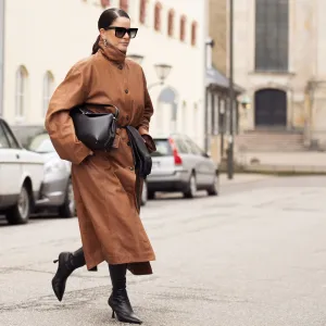 COPENHAGEN, DENMARK - JANUARY 31: Gili Biegun wears, long brown leather coat, black bag, black long leather gloves, sunglasses and black shoes during the Copenhagen Fashion Week Autumn/Winter 2025 on January 31, 2025 in Copenhagen, Denmark. (Photo by Raimonda Kulikauskiene/Getty Images)