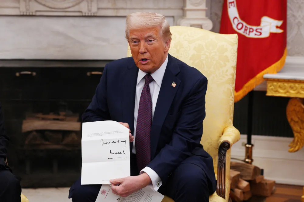 Donald Trump holds a letter from King Charles