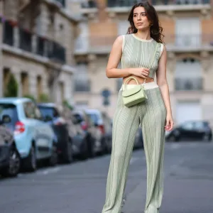 PARIS, FRANCE - AUGUST 16: Ketevan Giorgadze @katie.one wears a white and green striped / ribbed comfortable knitted green cropped t-shirt from Le Ger, matching white and green striped ribbed high waist comfortable loungewear trousers with elastic waistband from Le Ger, a sage green shiny leather crocodile print pattern crossbody bag from By Far, white shiny leather embossed LV monogram pattern sneakers from Louis Vuitton, on August 16, 2021 in Paris, France. (Photo by Edward Berthelot/Getty Images)