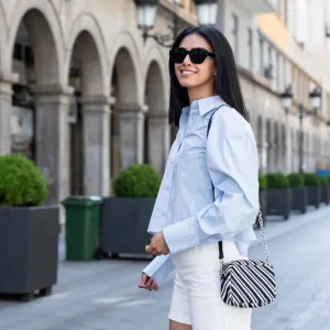 Young woman standing on street in front of building - stock photo